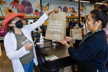 Francis Son photo courtesy Wild Onion Market- shoppers check out with a grocery bag