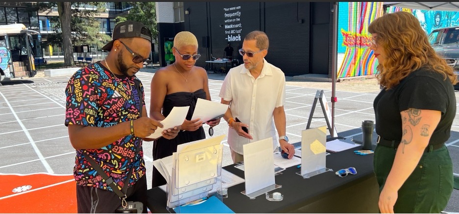 JitneyEV works to support mobility and electric vehicle charging and National Heritage Area visitors in Bronzeville. A Heritage Area booth at Overton Exchange Pulic Outdoor Plaza Grand Opening (Jitney EV Founder William Davis, third from left). (Photo courtesy City of Chicago)