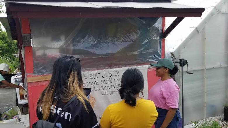 LVEJO fair participants looking at water justice sign